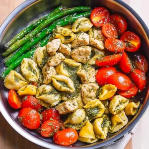 Pesto Chicken Tortellini with Spring Veggies on a White Plate